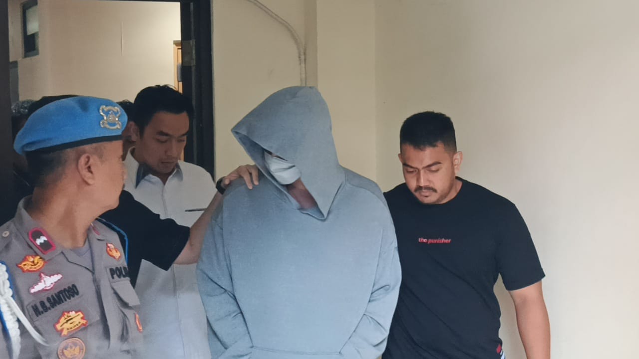 Fachri Albar kenakan sweater abu-abu saat digiring polisi sekitar pukul 14.11 WIB menuju Biddokkes (Bidang Kedokteran dan Kesehatan) untuk jalani pemeriksaan, Rabu (23/4/2025). [Indopop]